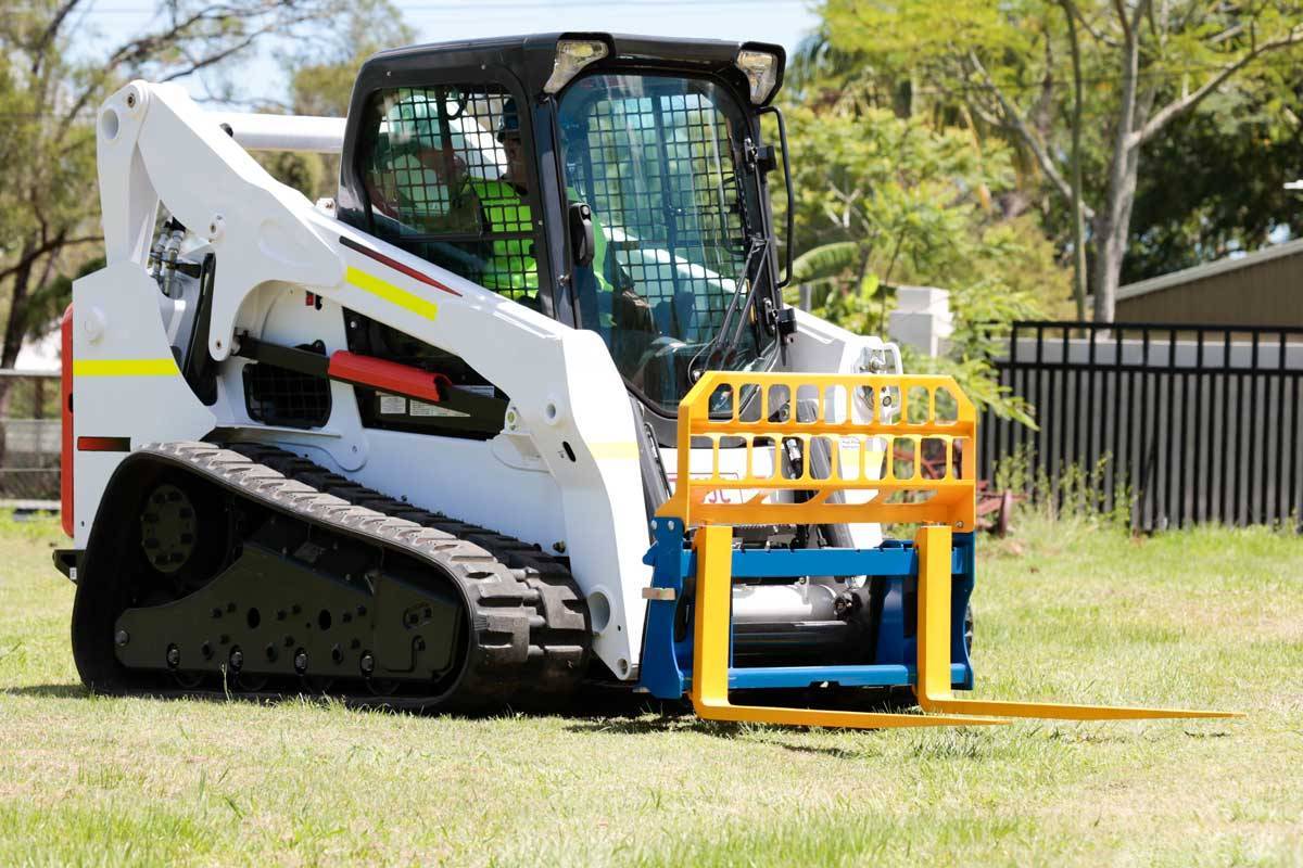 Skid steer pallet forks lifting a pallet