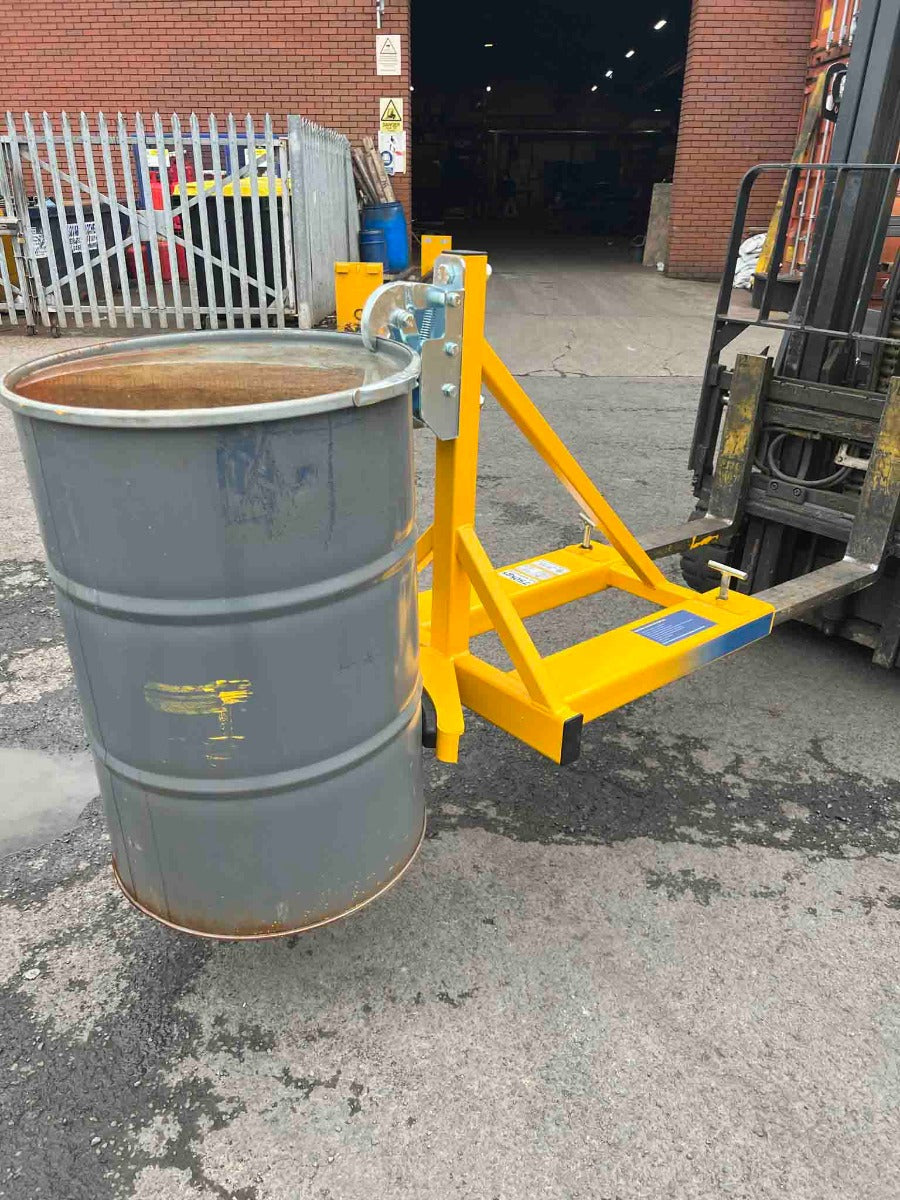Rim grip drum grab lifting a steel drum in a yard