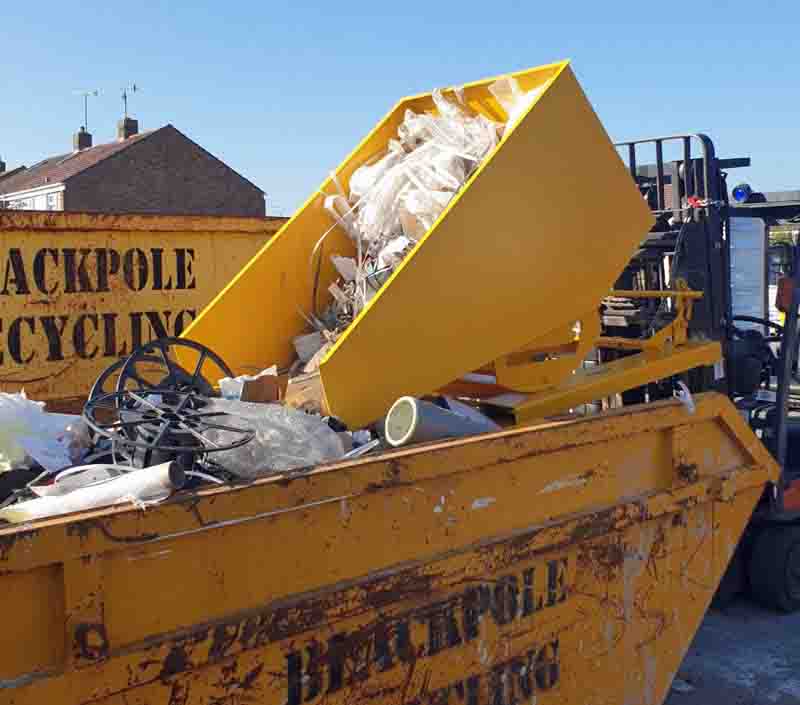 Roll forward tipping skip emptying waste into a skip