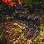 Root rake removing roots from the ground